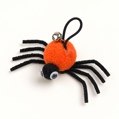 Le jouet araignée orange seul, pattes noires et grelot